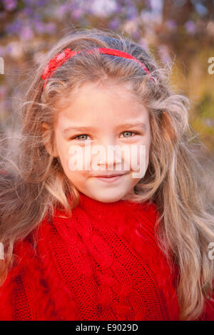 Jeune fille dans un poncho rouge sur fond de paysage d'automne Banque D'Images