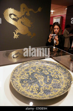 Vancouver, Canada. 16 octobre, 2014. Un visiteur prend des photos de la dynastie Ming's plate à motif de dragon à la Vancouver Art Gallery, à Vancouver, Canada, 16 octobre, 2014. 'La Cité Interdite : l'intérieur de la Cour des empereurs de la Chine' a présenté environ 200 artefacts précieux du Musée du Palais de Pékin. © Xinhua/Alamy Live News Banque D'Images