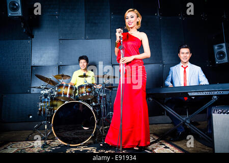 Chanteur professionnel asiatique batteur et clavier à enregistrer de nouveaux morceau ou l'album en studio Banque D'Images