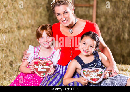 Famille bavaroise assis sur grange avec gingerbread Banque D'Images