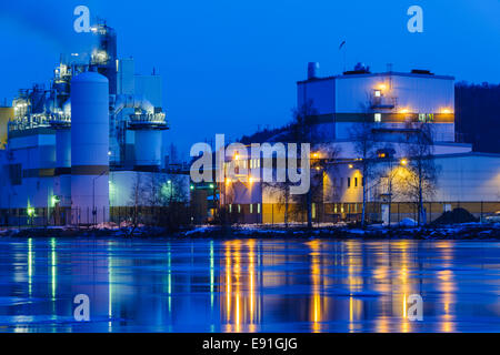 L'usine au bord de l'eau illuminée la nuit Banque D'Images
