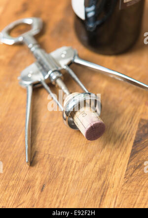 Un tire-bouchon de liège d'une bouteille de vin rouge. Banque D'Images