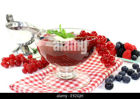 Un verre avec gelée de fruits rouges, sauce vanille et menthe Banque D'Images