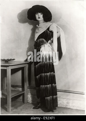 Jeune femme à la mode en robe longue avec pompon en plumes à la taille et foulard crêpe lié au cours de l'épaule, avec Hat, Portrait, vers 1922 Banque D'Images