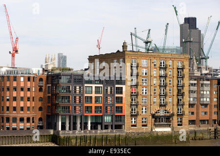 Grues à tour derrière les bâtiments anciens soutenue par des poteaux de bois le long des rives de la Tamise Londres Angleterre Banque D'Images