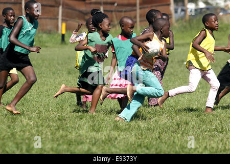 Kampala, Ouganda. October 18th, 2014. Les enfants ougandais défavorisés prennent le temps de jouer au rugby. Bon nombre des jeunes qui habitent dans les bidonvilles ont bénéficié dans l'éducation grâce au financement par des expatriés qui aiment le sport. Credit : Samson Opus/Alamy Live News Banque D'Images