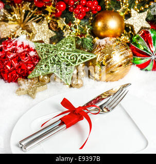 Les branches d'arbre de Noël avec ses décorations en rouge et or. table de fête place mise au point sélective. Banque D'Images