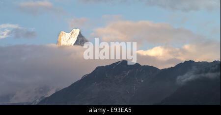 La vue sur les sommets enneigés des montagnes de l'Himalaya dans la lumière du soleil levant. Banque D'Images