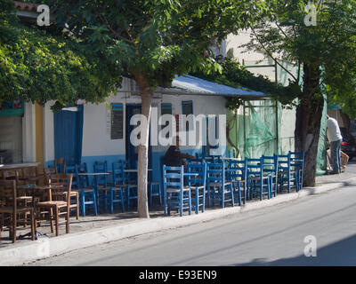 Chaussée typiquement grec, café bleu coloré de tables et de chaises en bois, Pythagoreion village de l'île de Samos en Grèce Banque D'Images