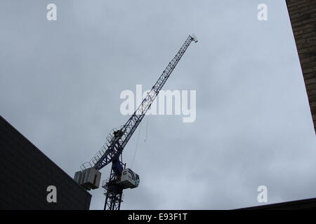 Londres, Royaume-Uni. 18 octobre, 2014. Couple de personnes âgées s'échapper d'une blessure, crochet de grue maison frappe dans la région de Edmonton. Les équipes de pompiers et ambulanciers ont assisté à une propriété nationale suite à l'annonce d'un effondrement de la grue dans la région de Edmonton à autour de midi . Il semble que le crochet d'une grue à tour de flèche relevable a frappé la maison causant des dommages à la toiture, le couple de personnes âgées ont été évalués par le London Ambulance Service mais ont été trouvés à être blessé. Credit : Hot Shots/Alamy Live News Banque D'Images