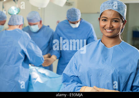 Young Asian Indian female femme infirmière médecin chirurgien avec son équipe chirurgicale interracial travaillant sur un patient en chirurgie de l'hôpital Banque D'Images