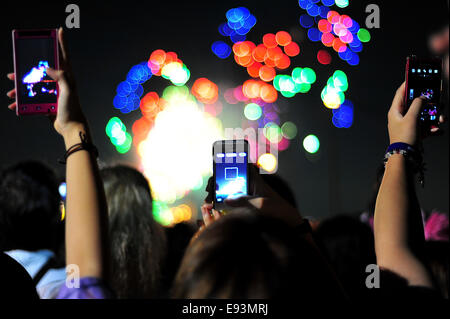 La foule se soulève leurs téléphones pour photographier le feu d'artifice lors du Festival Fireworks Adachi Banque D'Images