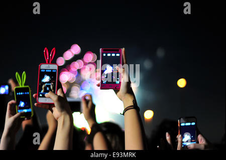 La foule se soulève leurs téléphones pour photographier le feu d'artifice lors du Festival Fireworks Adachi Banque D'Images