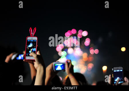 La foule se soulève leurs téléphones pour photographier le feu d'artifice lors du Festival Fireworks Adachi Banque D'Images