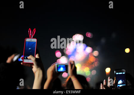 La foule se soulève leurs téléphones pour photographier le feu d'artifice lors du Festival Fireworks Adachi Banque D'Images