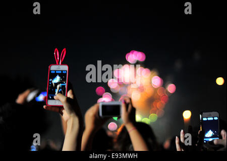 La foule se soulève leurs téléphones pour photographier le feu d'artifice lors du Festival Fireworks Adachi Banque D'Images