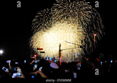 La foule se soulève leurs téléphones pour photographier le feu d'artifice lors du Festival Fireworks Adachi. Banque D'Images