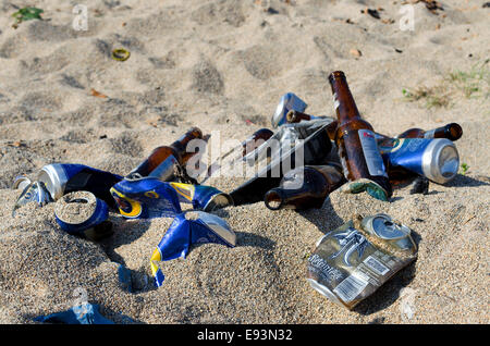 Des canettes de bière et des bouteilles à gauche sur la plage Banque D'Images