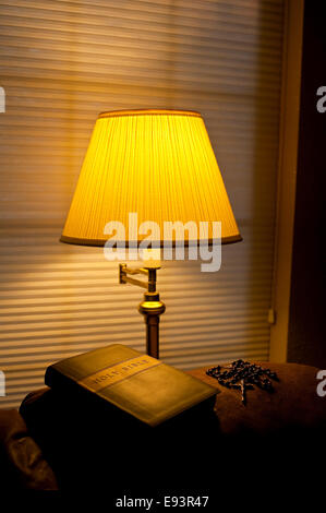 Bible sur l'arrière de la table avec la lumière solaire et la lumière chaude de la lampe avec rosaire Banque D'Images