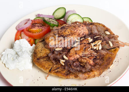 Musakhan, sumac palestinienne traditionnelle, de poulet sur une assiette avec une salade et yaourt, high angle Banque D'Images