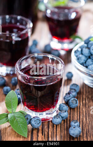 Liqueur de bleuets dans un verre (sur fond de bois) Banque D'Images