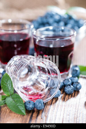 Liqueur de bleuets dans un verre (sur fond de bois) Banque D'Images