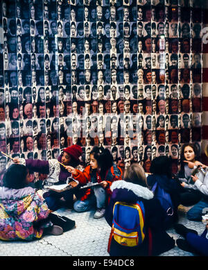 Les écoliers se rendant sur Ellis Island Immigration Museum, assis en face d'un drapeau de faces, New York, NY, USA Banque D'Images