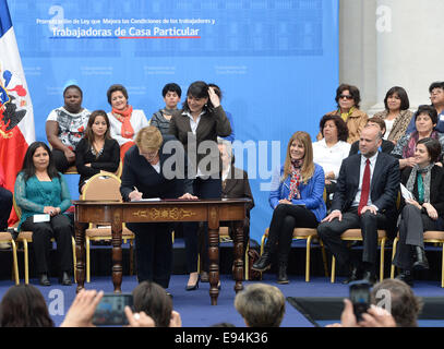 Santiago, Chili. 19 Oct, 2014. Image fournie par la Présidence du Chili montre la présidente du Chili Michelle Bachelet signer la promulgation de la Loi des travailleurs dans le Palais de la Moneda, Santiago, capitale du Chili, le 19 octobre 2014. © Présidence du Chili/Xinhua/Alamy Live News Banque D'Images