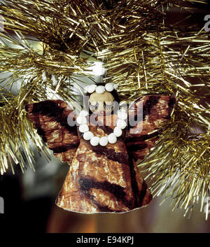 Un ange de Noël hawaïen tissu tapa avec un lei de coquillages autour du cou est suspendu dans un arbre de Noël à Honolulu sur Oahu à Hawaii, USA. Banque D'Images