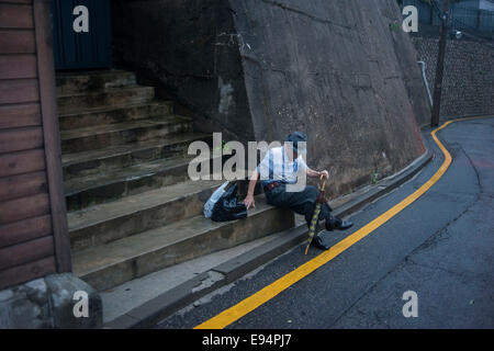 10 septembre 2013, Séoul, Corée du Sud - Corée - Un homme âgé repose sur une étape sur la route escarpée dans village de Bukchon Banque D'Images