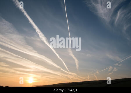 Des traînées de vapeur chimique,plans,sentiers, sunrise Mwnt,West Wales Banque D'Images