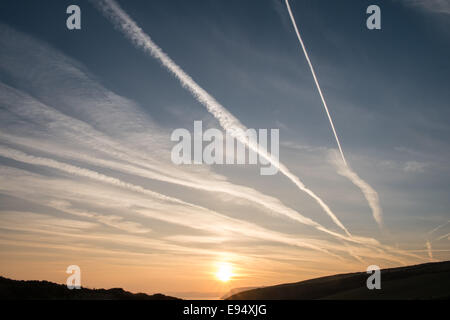 Des traînées de vapeur chimique,plans,sentiers, sunrise Mwnt,West Wales Banque D'Images