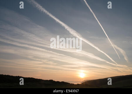 Des traînées de vapeur chimique,plans,sentiers, sunrise Mwnt,West Wales Banque D'Images