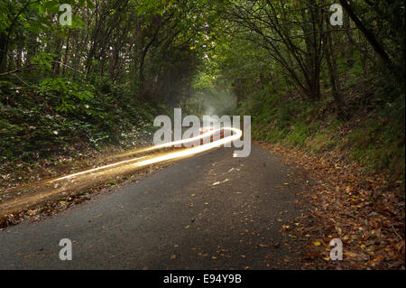 Suspendu dans l'air Sentiers de la voiture survole le pays étroit sombre seule voie sur l'image terne des pluies Banque D'Images