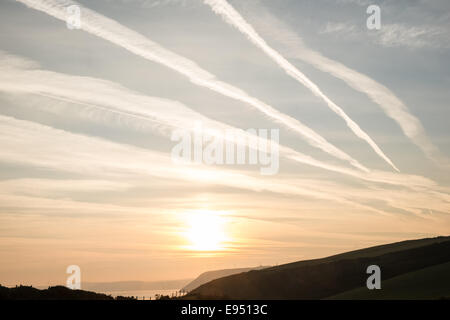 Des traînées de vapeur chimique,plans,sentiers, sunrise Mwnt,West Wales Banque D'Images