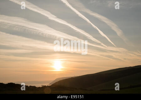 Des traînées de vapeur chimique,plans,sentiers, sunrise Mwnt,West Wales Banque D'Images