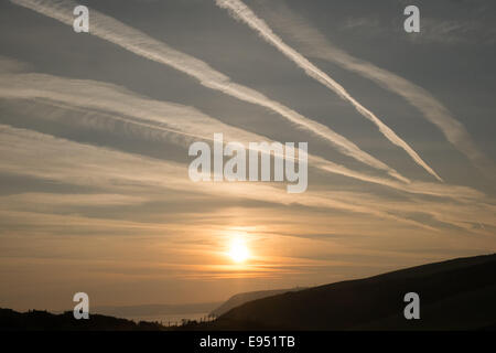 Des traînées de vapeur chimique,plans,sentiers, sunrise Mwnt,West Wales Banque D'Images