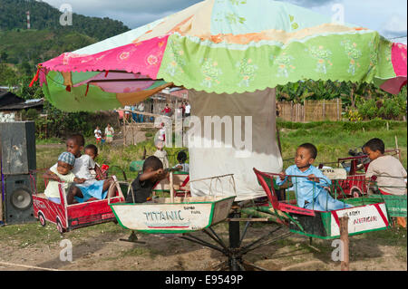 Les jeunes passagers sur un carrousel, self-made carrousel pour enfants lors d'une foire, Ranomafana, Madagascar Banque D'Images