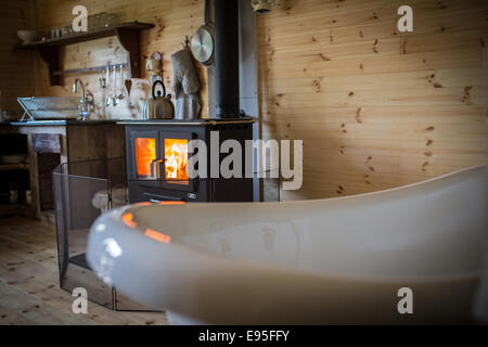 Baignoire à l'ancienne près de poêle à bois à holiday lodge Banque D'Images