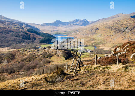 Bain stile sur sentier au-dessus de Capel Curig avec vue d'Nantygwryd et le Snowdon Horseshoe dans le parc national de Snowdonia au Pays de Galles UK Banque D'Images