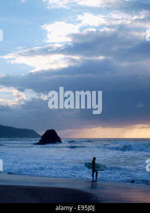 Surfer au coucher du soleil, Widemouth Bay, Bude, Cornwall, UK Banque D'Images