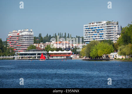 En été, un petit bateau à voile rouge sur le lac de l'Allier (Vichy). Petit voilier à voiles rouges sur le Lac d'Allier, à Vichy. Banque D'Images