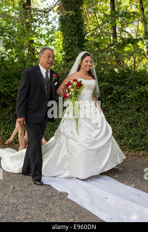 Père sa fille marche dans l'allée pendant la cérémonie du mariage à Marin Art et jardin, centre ville de Ross, le comté de Marin, en Californie Banque D'Images