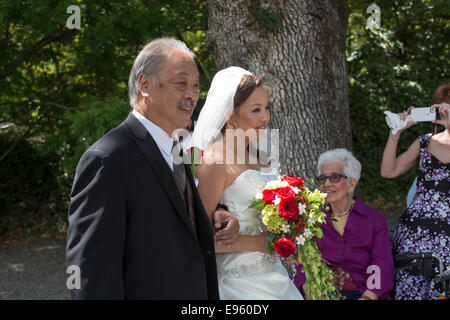 Père sa fille marche dans l'allée pendant la cérémonie du mariage à Marin Art et jardin, centre ville de Ross, le comté de Marin, en Californie Banque D'Images