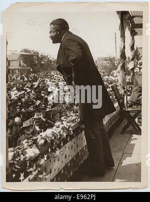 Cette photographie montre le président Theodore Roosevelt lors de sa visite à North Yakima, Washington. L'image capture Roosevelt s'adressant à une foule nombreuse, probablement lors de sa campagne présidentielle ou de ses discours publics. Son leadership et son lien avec le peuple se reflètent dans ce moment historique. Banque D'Images