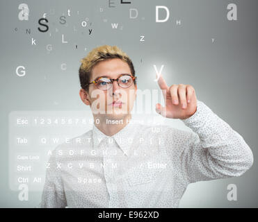 Jeune homme d'appuyer sur bouton application sur ordinateur avec écran tactile Banque D'Images