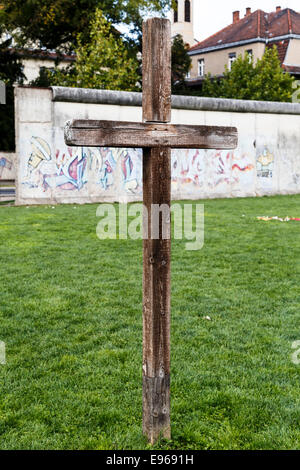 La croix commémorative de la paroisse Sophien en face de l'article reste de mur de Berlin au mur de Berlin Memorial Park Banque D'Images