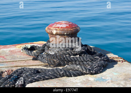 Old rusty amarre bollard on pier Banque D'Images