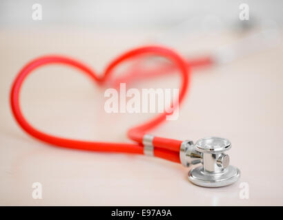 Stéthoscope médical rouge en forme de cœur sur la table Banque D'Images