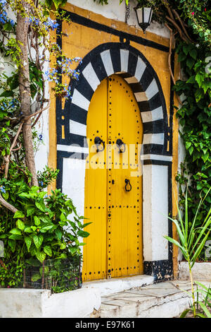 Un jaune typique, porte en bois cloutée à Sidi Bou Said, Tunisie. Banque D'Images